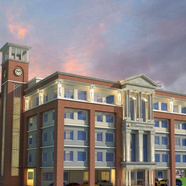 Brick campus building with a clock tower and classical columns, surrounded by trees at dusk.”,
